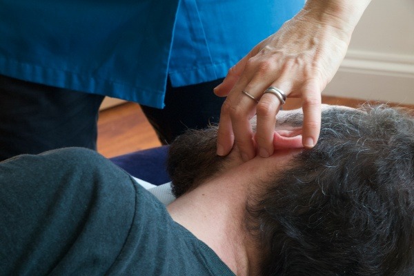 Chiropractic adjustment to client's ear.